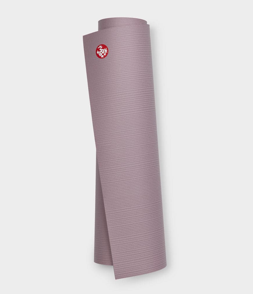 Manduka PRO 6mm yoga mat shown rolled beside its flat working surface